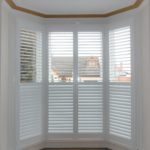 Tall white bay window shutter