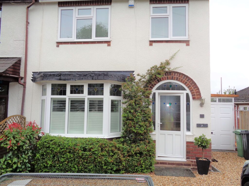 traditional english home with white bay window shutters